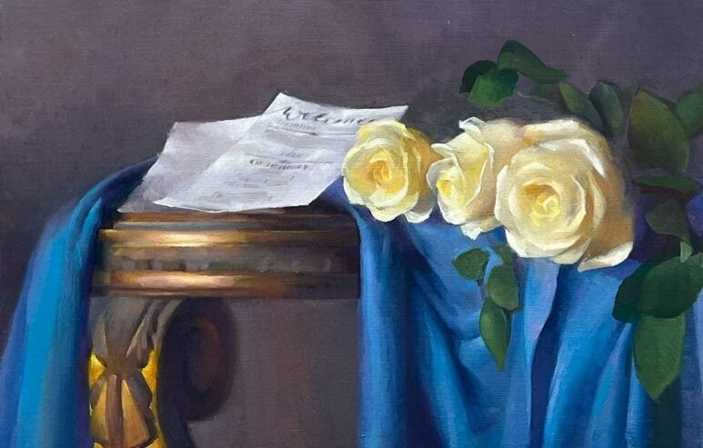 Painting of white roses and a letter on top of blue fabric
